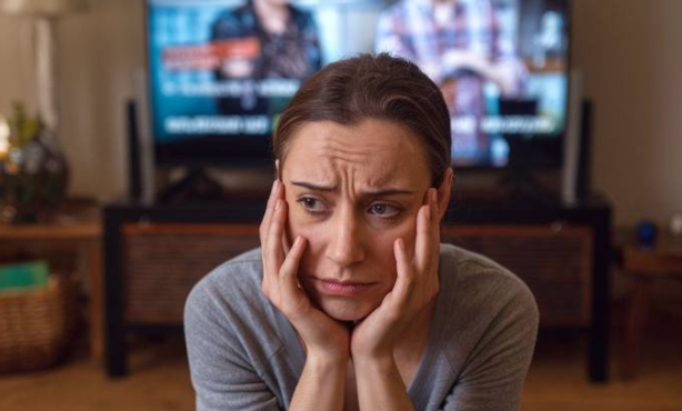 Femme tournant le dos à la télévision sans sous-titrage, illustrant la nécessité du sous-titrage universel